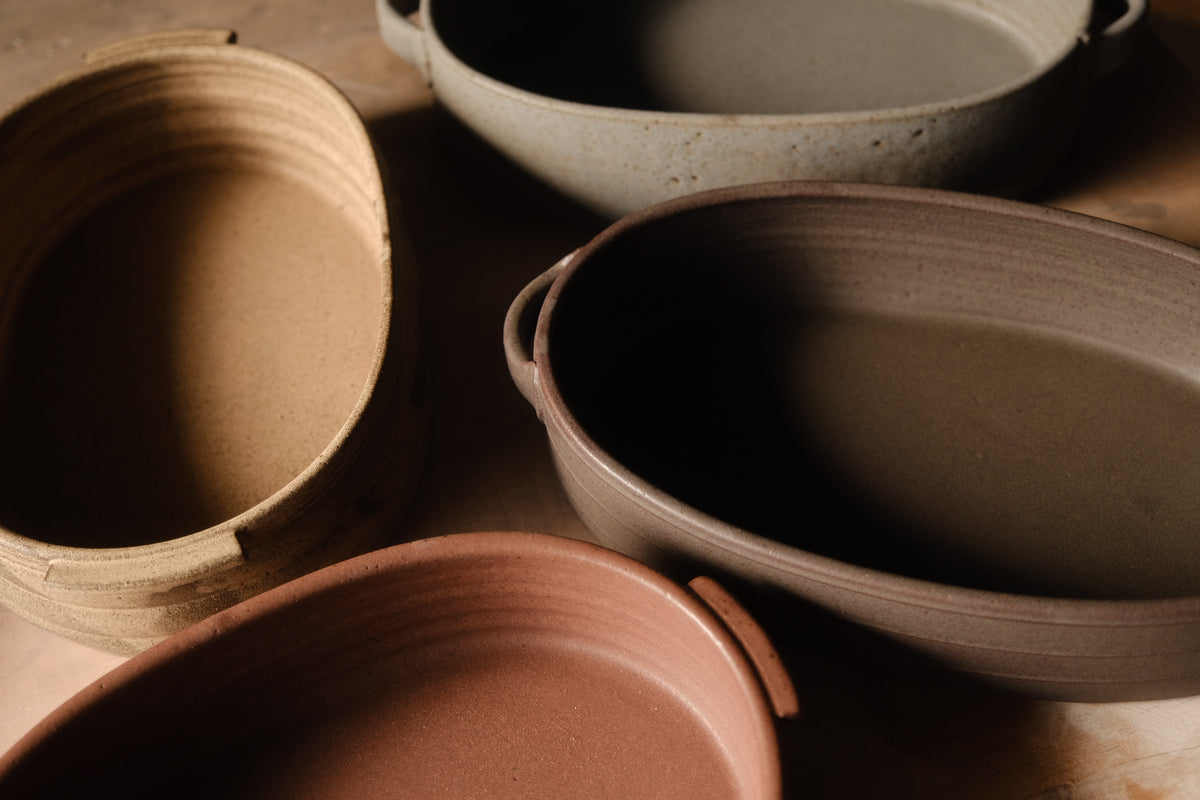 Storm Hot Dish: grouped with three other oval ceramic casserole dishes in different glaze finishes on a work table.