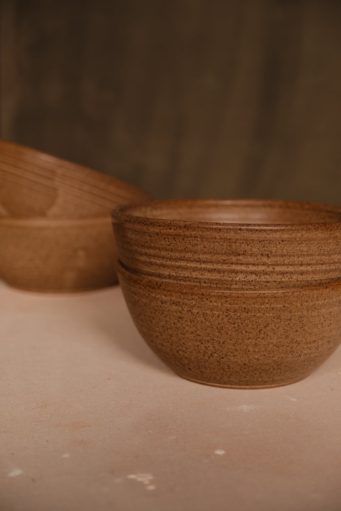 Speckled Buff Ramen Bowl, two bowls neatly stacked in foreground on fabric with a third bowl in soft focus behind
