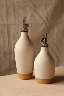 Wander Oil Bottle pair in off-white glaze, tall bottle forward and small bottle offset to the right.