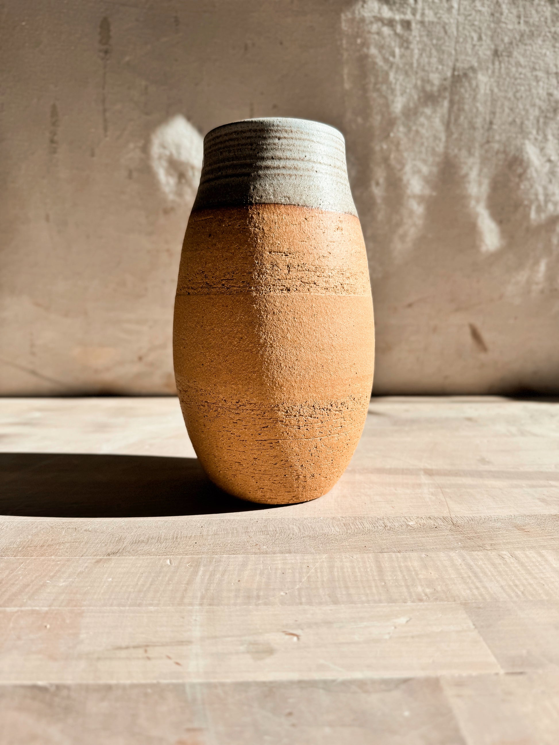 High Desert Vase in short barrel shape without botanicals, showing textured raw clay body and horizontally grooved glazed rim