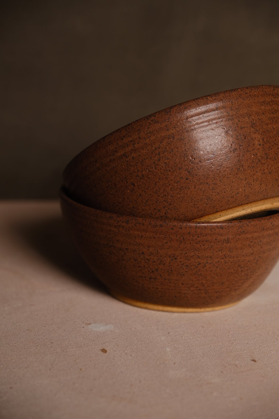 Speckled Buff Ramen Bowl, close profile of two stacked bowls resting on a cloth surface with unglazed foot