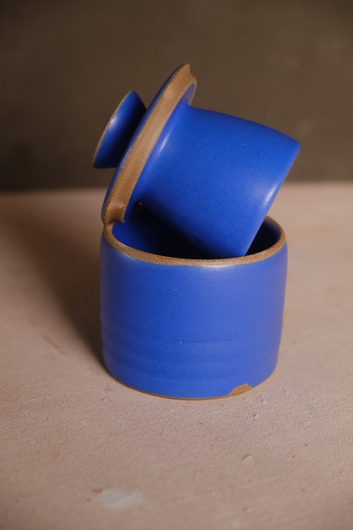 Butterbell ceramic keeper with vibrant cobalt blue satin glaze, bell lid leaning inside crock with exposed raw clay rims.