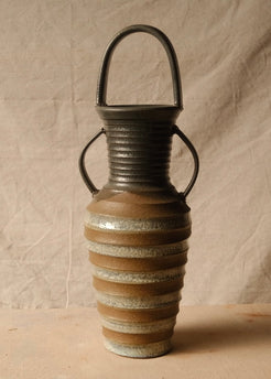 Eros Amphora front-facing studio view, highlighting glossy glaze highlights across the ribbed ceramic body and rim.