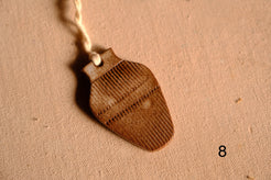 Ceramic ornament bulbous vase silhouette covered in vertical ribbed texture and a dashed cross band, numbered eight.