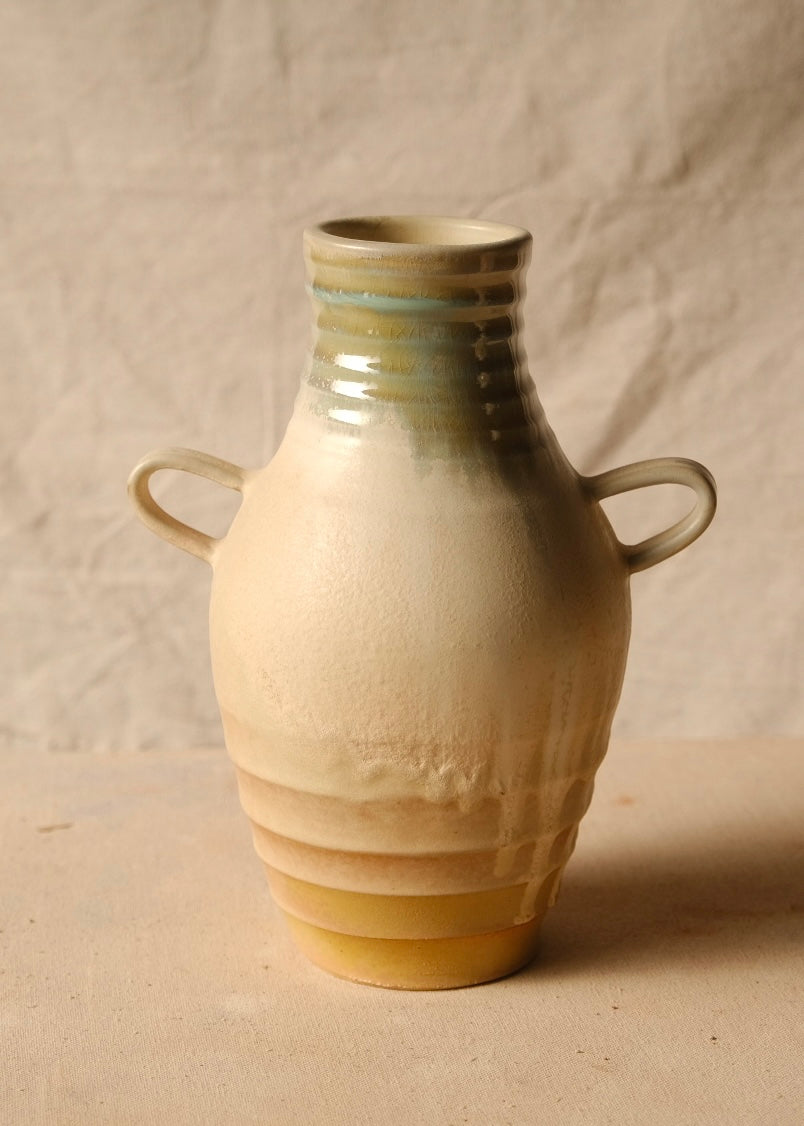 Woodfire Amphora # 4 front view with two loop handles, grooved neck, and textured body on neutral fabric.