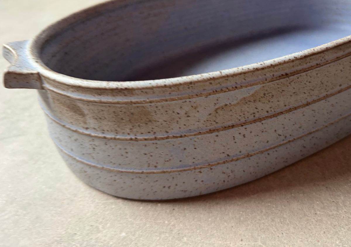 Speckle Cenote Hot Dish, close angled view focusing on the speckled blue interior glaze and ribbed outer wall.