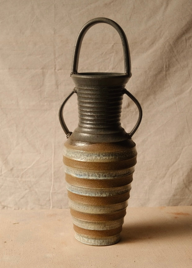 Eros Amphora angled front view showing the textured horizontal ridges and glazed bands across the tapered body.
