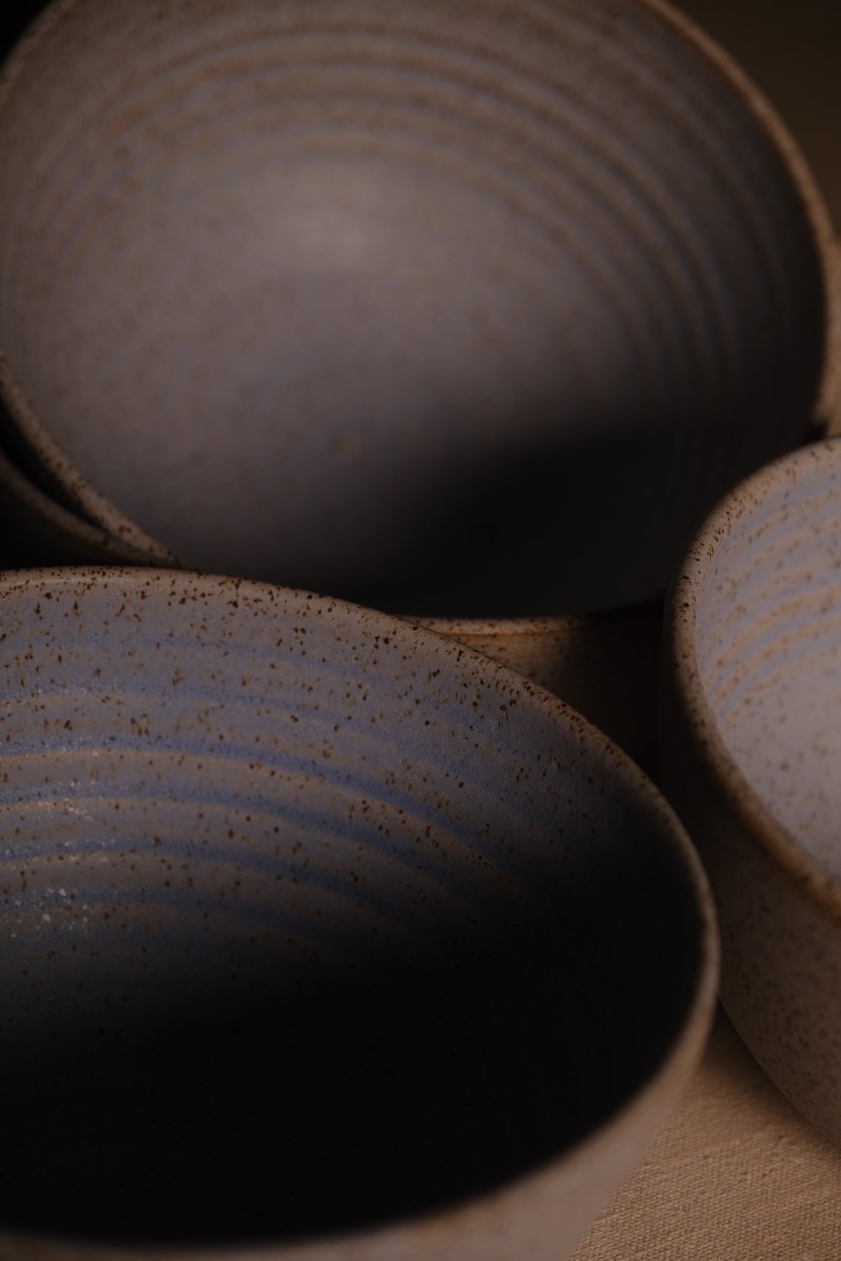 Speckled Buff Ramen Bowl, high overhead cluster of three open bowls showing interior ribbed contours