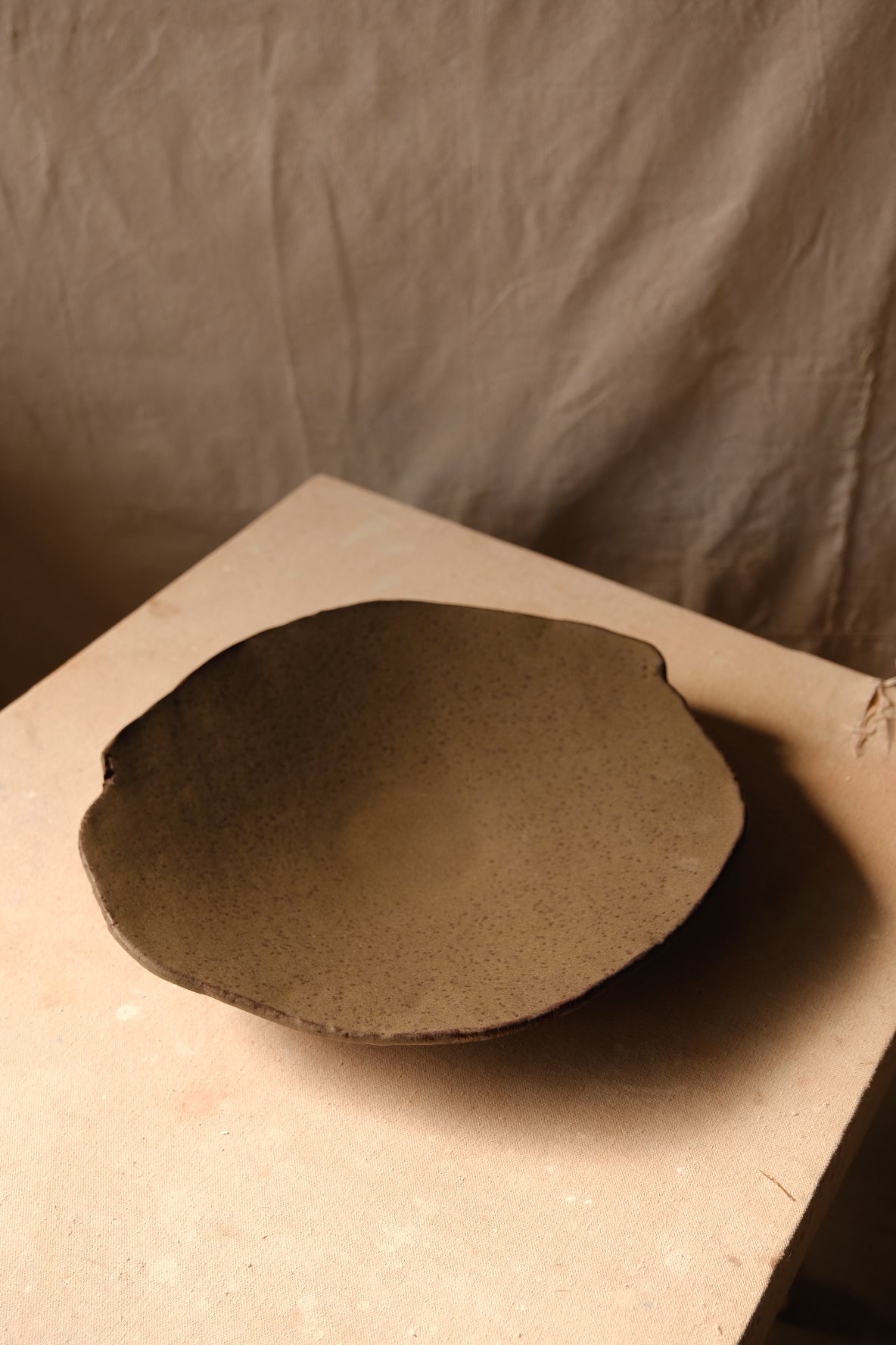 Mesa Platter in a low three-quarter perspective highlighting its shallow curved basin and organic lip.