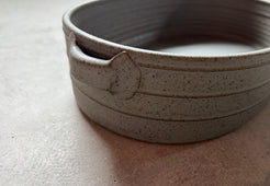 Speckle Storm Hot Dish, close-up of the curved rim, side grooved ridges, and attached loop handle with speckled glaze.