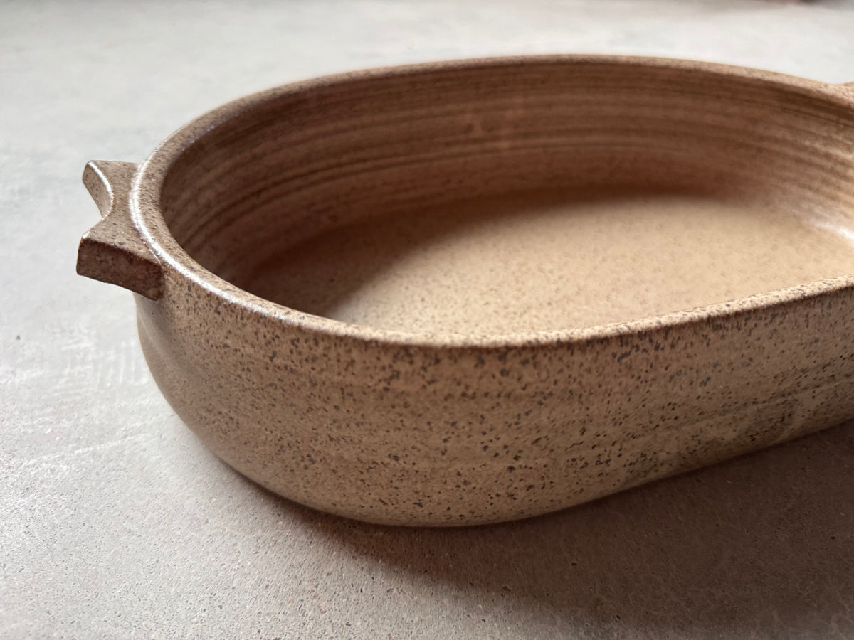 Speckle Maize Hot Dish, low profile view of the shallow oval baking dish showing its curved side and handle.