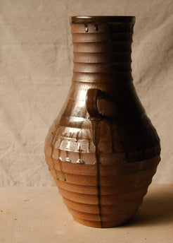 Woodfire Amphora #1, opposite profile view centered on one curved handle and layered drip lines over the ribbed surface.