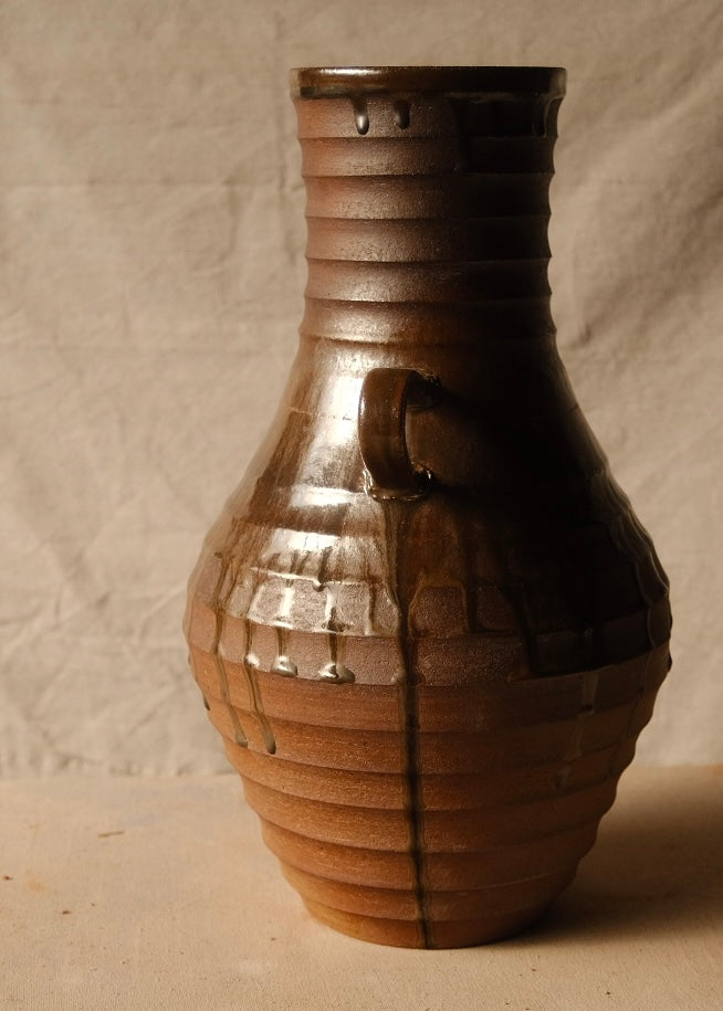 Woodfire Amphora #1, opposite profile view centered on one curved handle and layered drip lines over the ribbed surface.