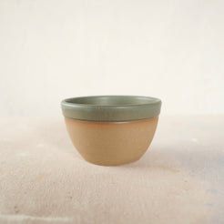 Country Rim Soup Bowl in unglazed stoneware with a sage green glazed rim on a pale surface.