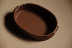 Iron Hot Dish ceramic casserole dish seen from a higher three-quarter angle, showing interior throwing lines and depth.