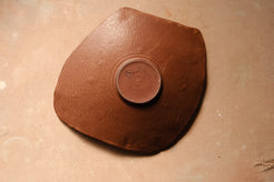 Mesa Platter underside with warm glaze, stamped bare clay foot ring, and subtle glaze sheen across the base.