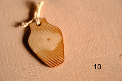Ceramic ornament tapered vase cutout with fine horizontal ribbed lines across the clay surface, numbered ten.