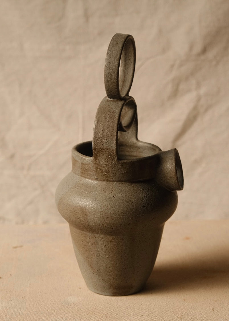 Rising Moon stoneware pitcher angled to the right, showing the thick loop handle, rim interior, and protruding round spout.