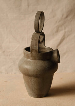 Rising Moon stoneware pitcher angled to the right, showing the thick loop handle, rim interior, and protruding round spout.