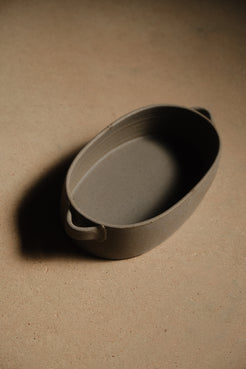 Storm Hot Dish: elevated three-quarter view of the full oval baker showing both loop handles and casting a shadow.