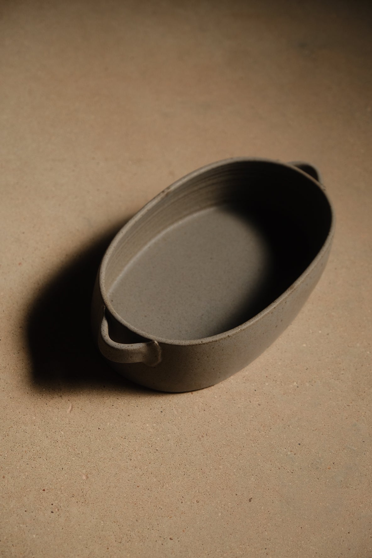 Storm Hot Dish: elevated three-quarter view of the full oval baker showing both loop handles and casting a shadow.