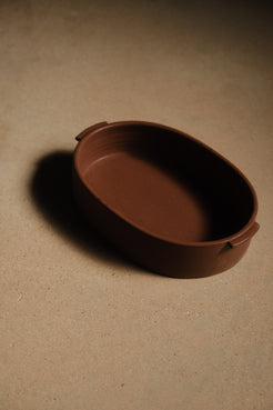 Iron Hot Dish ceramic casserole dish in a full vertical view, resting empty on a neutral stone surface.