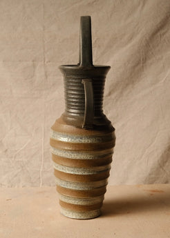 Eros Amphora side profile in softer lighting, displaying the grooved neck, straight handle, and ribbed silhouette.