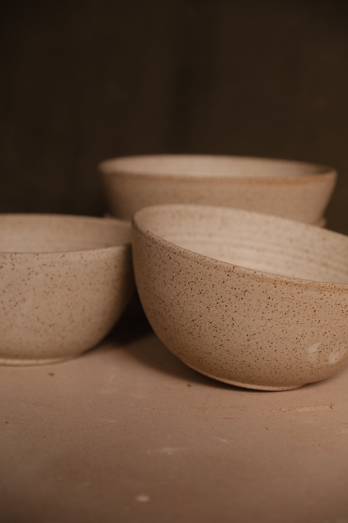 Speckled Buff Ramen Bowl, eye-level view of three bowls arranged on a studio surface showing smooth exterior