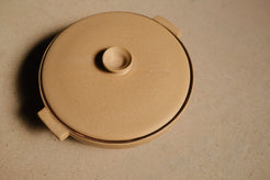 Satin Sand Lidded Hot Dish, three-quarter elevated view of the flat lid seated between two side tab handles.