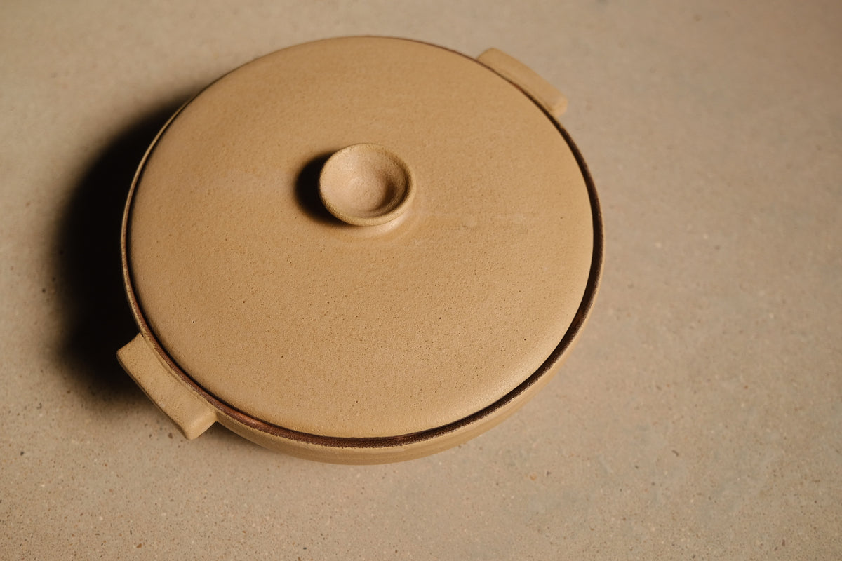 Satin Sand Lidded Hot Dish, three-quarter elevated view of the flat lid seated between two side tab handles.