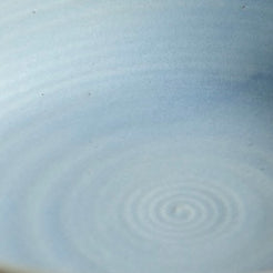 Fat Rim Dinner Plate glaze swatch, close-up of pale blue-grey glaze showing subtle spiral center ridges.