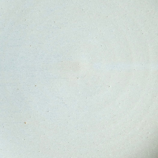 Fat Rim Dinner Plate glaze swatch, close-up of warm off-white glaze with subtle earthy speckles.