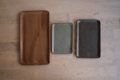 Trinket Tray trio arranged side by side in a row across a light wood table, top-down view showing size differences.