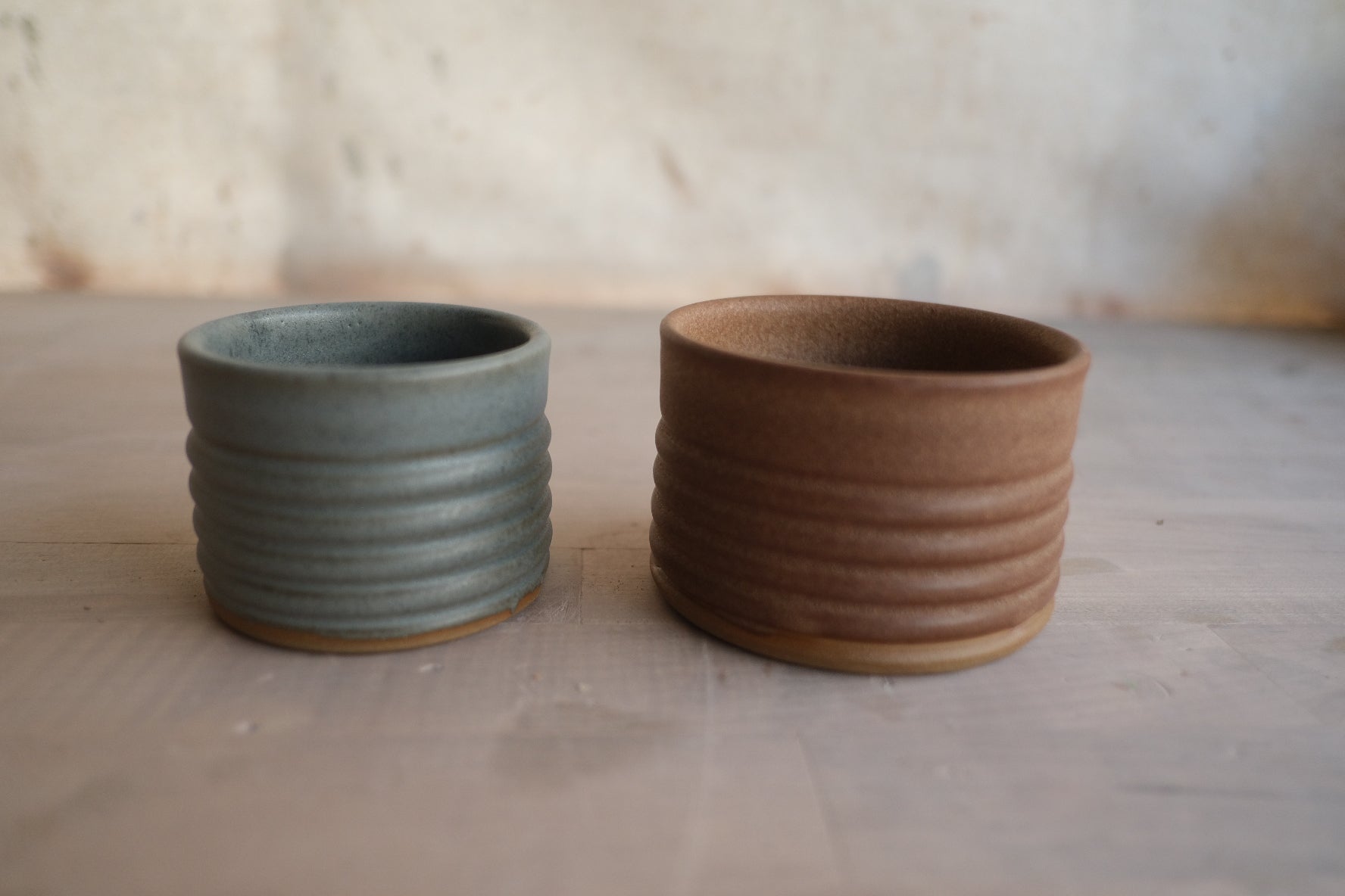 Textured Ramekins in two sizes side by side on a light surface, showing ridged horizontal grooves and raw clay feet.