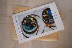 Glaze Card folded closed on a kraft envelope, showing the printed cover photo of ceramic dinnerware and gold flatware.