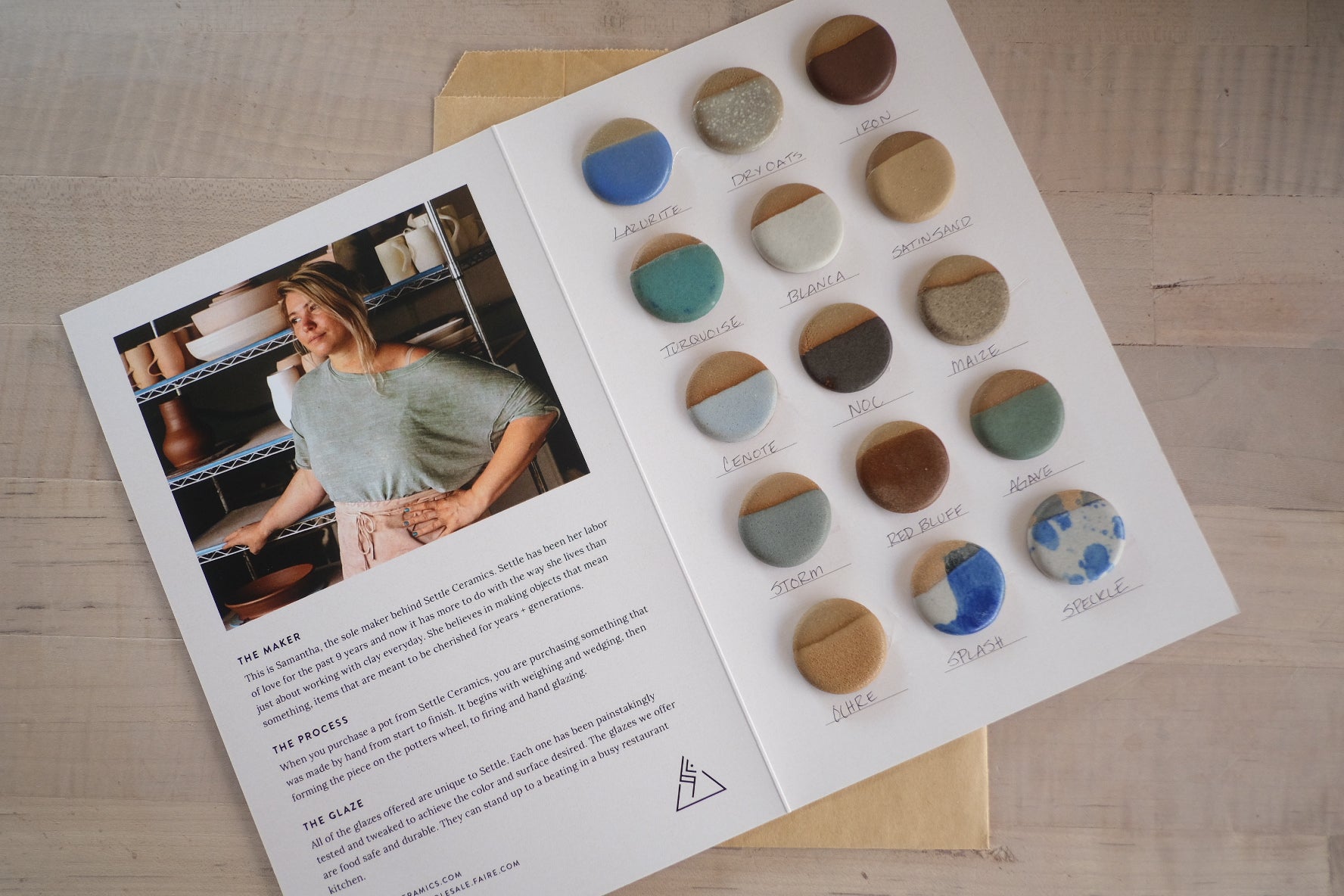 Glaze Card opened flat on a brown paper envelope, displaying sixteen round ceramic sample chips beside printed studio text.