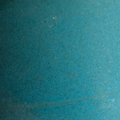 Fat Rim Dinner Plate glaze swatch, close-up of mottled aqua-blue satin ceramic glaze texture.