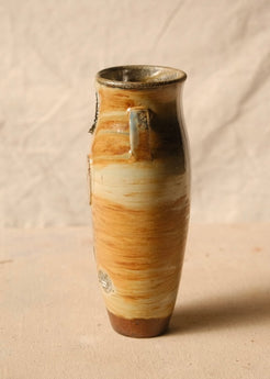 Woodfire Amphora #7, side view centered on one small strap handle, revealing raised kiln marks along the left ceramic edge