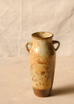 Woodfire Amphora #8 standing upright on cloth, showing its two side handles, flared rim, and unglazed dark base.