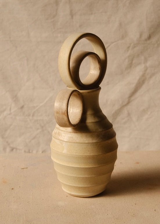 Within Vase seen at a three-quarter angle with its round handle turned forward and nested ring stopper standing upright.