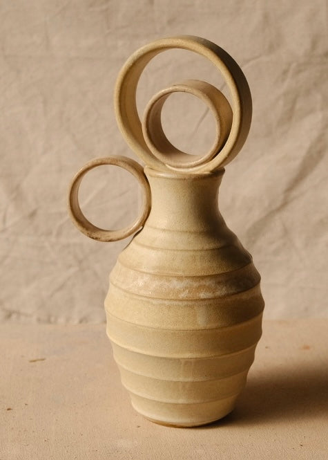 Within Vase viewed from the opposite side with its circular ring handle pointing left and ribbed stoneware body.