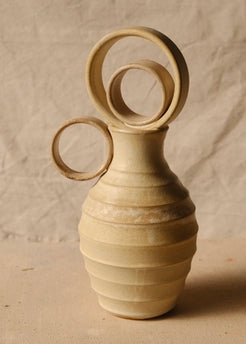Within Vase viewed from the opposite side with its circular ring handle pointing left and ribbed stoneware body.