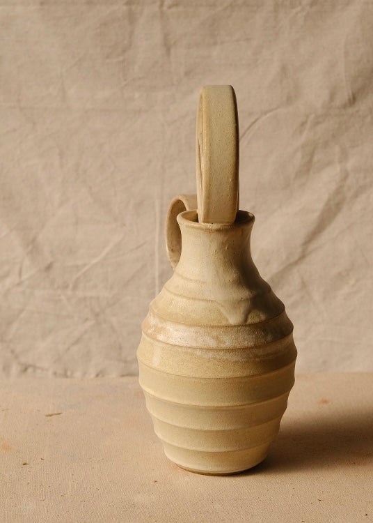 Within Vase shown from the edge profile with nested ring stopper viewed end-on and handle visible along the left curve.