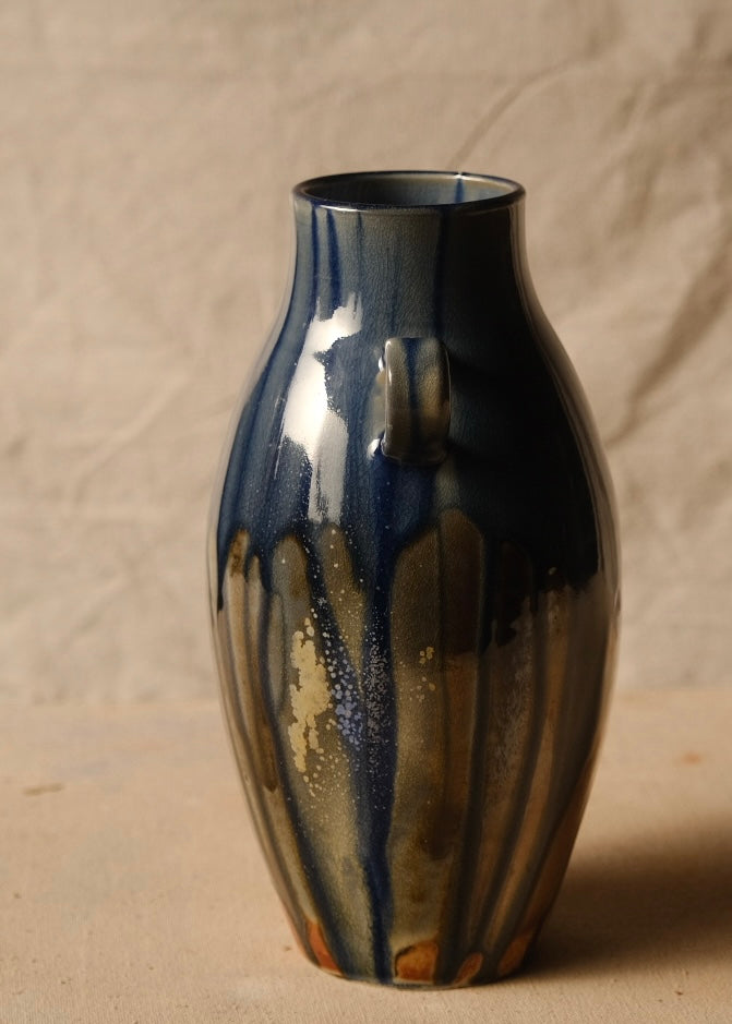 Woodfire Amphora #9, side profile showing one handle centered and vertical speckled glaze runs over warm clay.