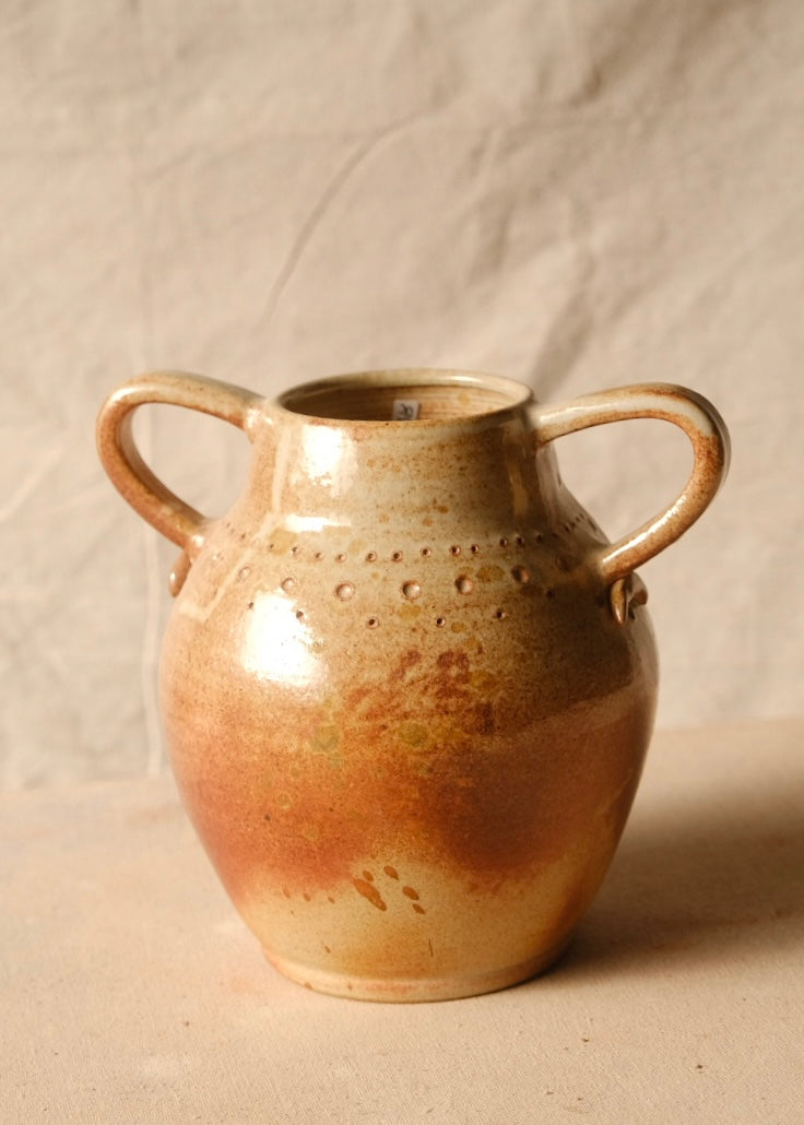Woodfire Amphora #10 ceramic jar, front view showing two loop handles and stamped dot patterns on a canvas surface