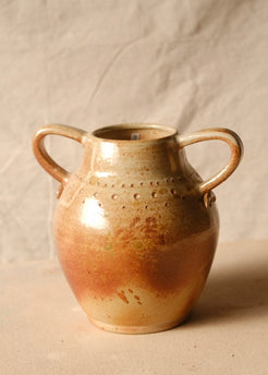 Woodfire Amphora #10 ceramic jar, front view showing two loop handles and stamped dot patterns on a canvas surface