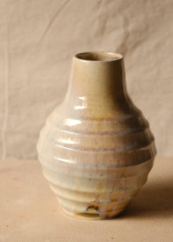Woodfire Ripple Vase, rotated view highlighting horizontal thrown ridges, gloss glaze with warm blush, and tapered opening.