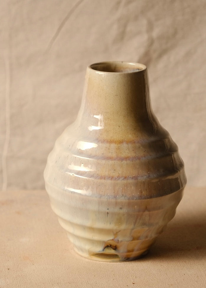 Woodfire Ripple Vase, rotated view highlighting horizontal thrown ridges, gloss glaze with warm blush, and tapered opening.