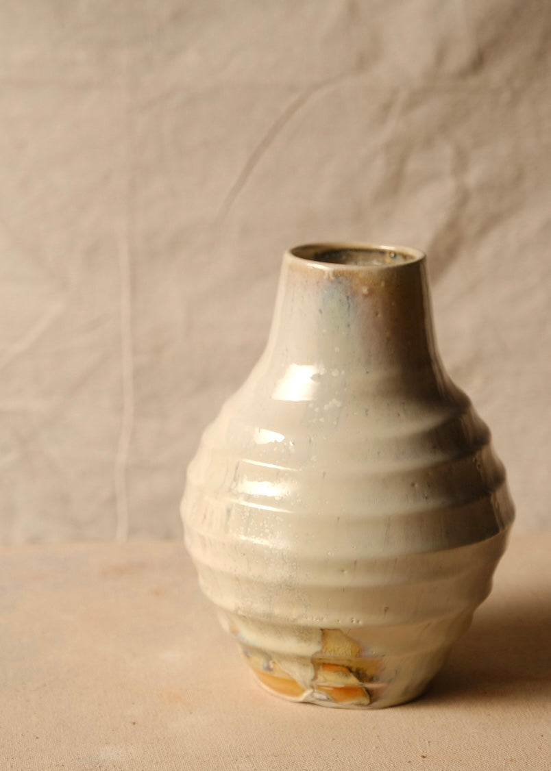 Woodfire Ripple Vase, front-facing view showing wide horizontal ridged body, smooth neck, and unglazed patch along foot.