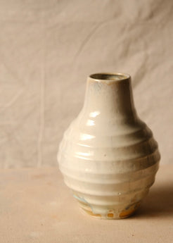Woodfire Ripple Vase, front profile showing rounded ridged profile, glossy light glaze pooling, and flat raw base rim.